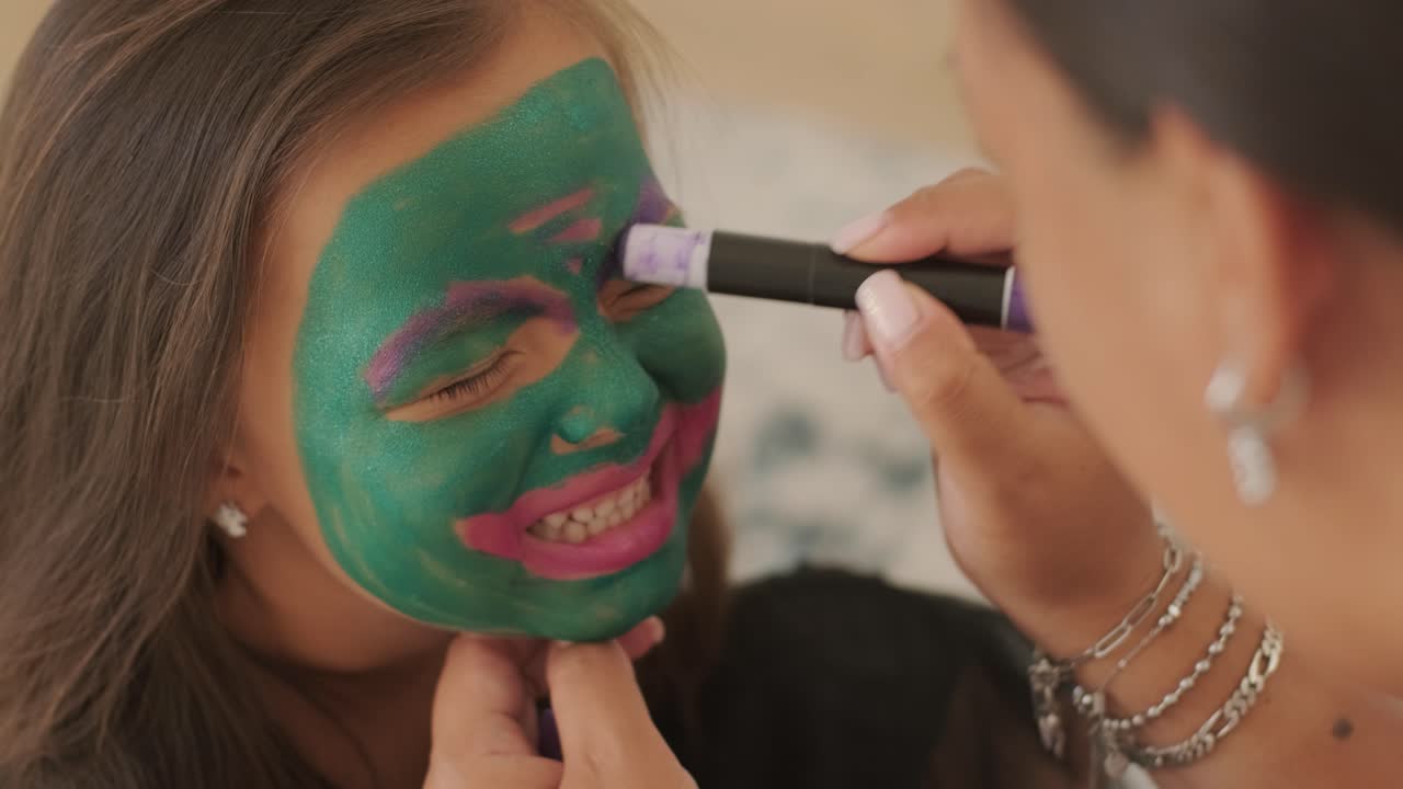 niña pequeña pintando la cara para halloween