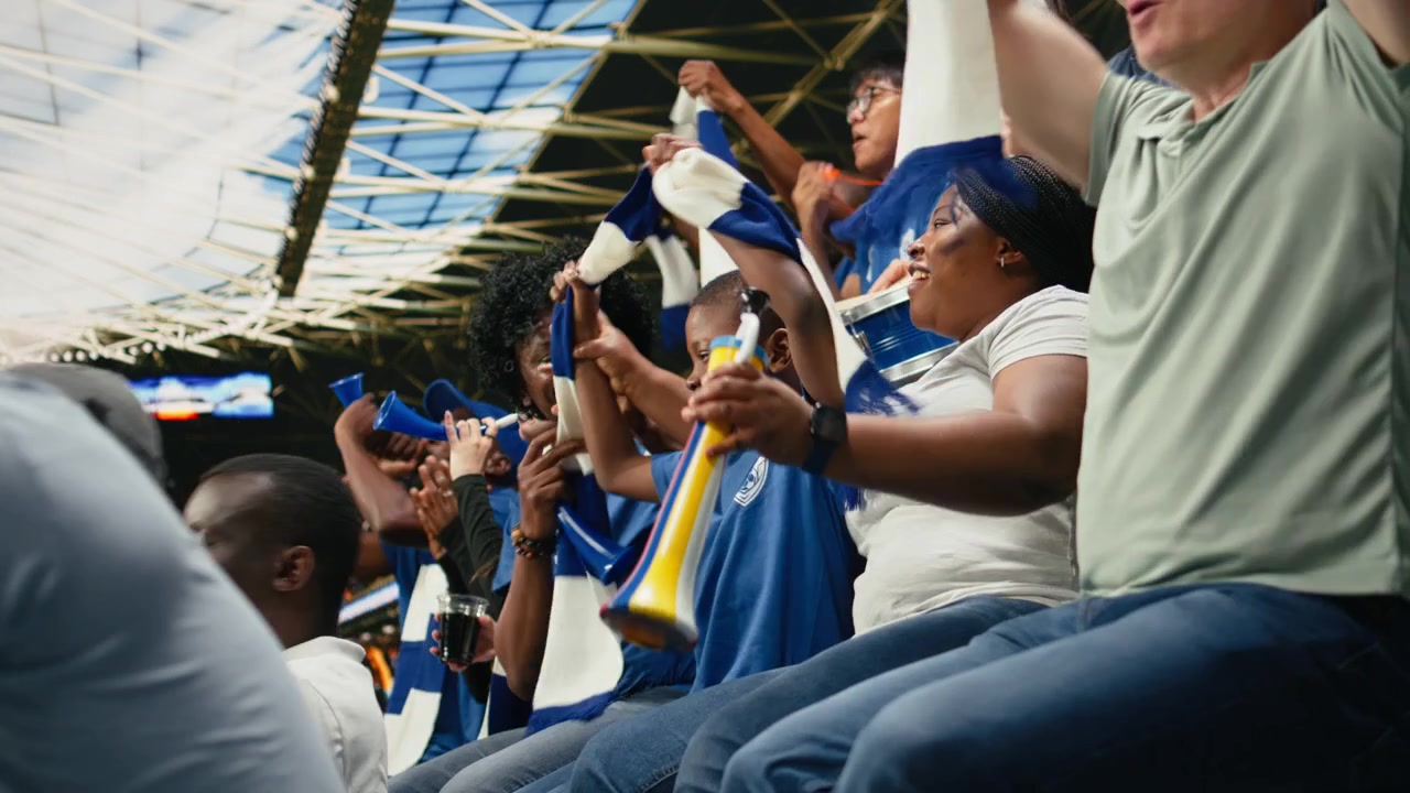 Familia afroamericana celebrando con un niño pequeño durante un emocionante partido de fútbol