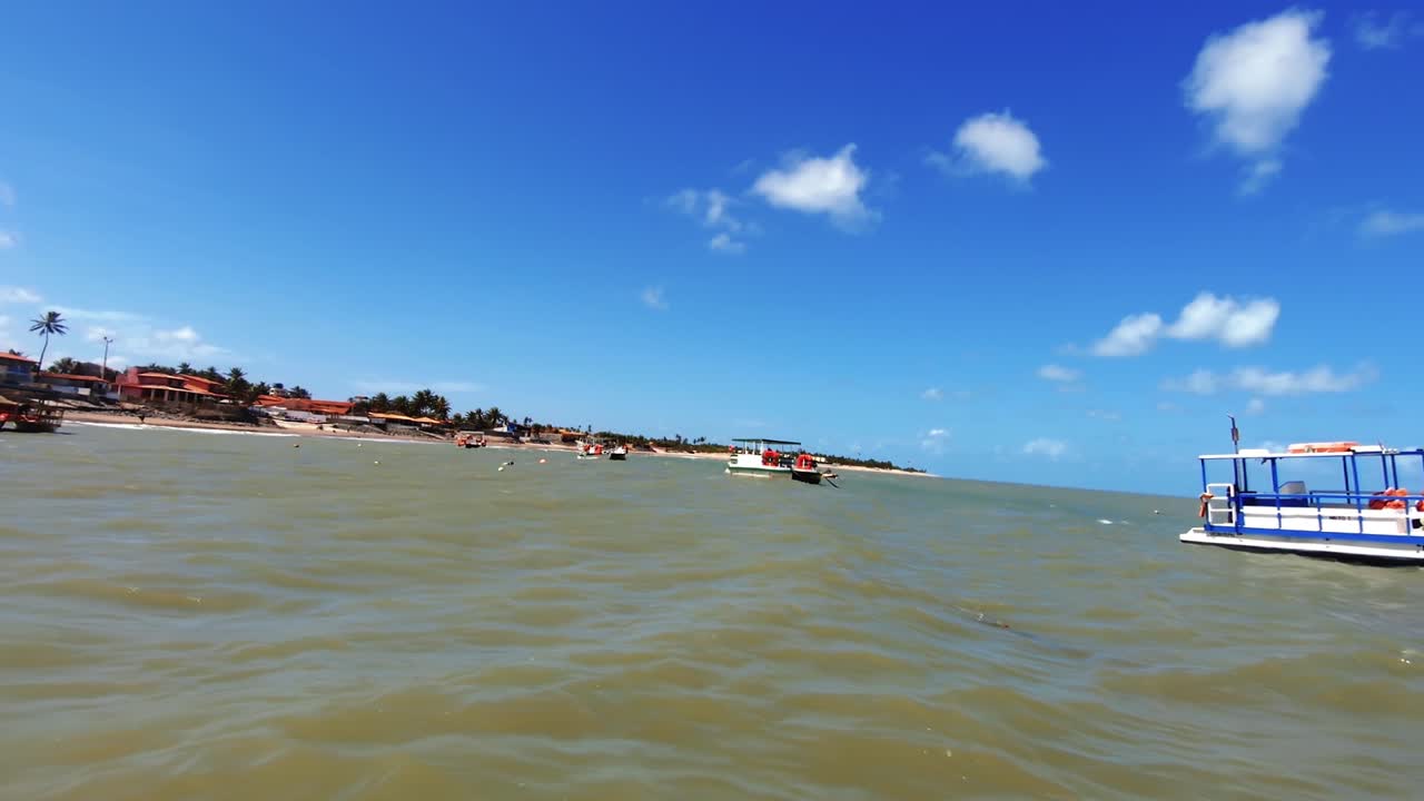varios barcos turísticos atracados a lo largo de la costa del maracajau tropical en rio grande do norte, brasil en un cálido y soleado día de verano