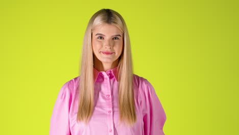 Beautiful-Blonde-Woman-Looking-At-Camera,-Smiling-and-Waving-Hand-Greeting,-Colorful-Studio-Shot