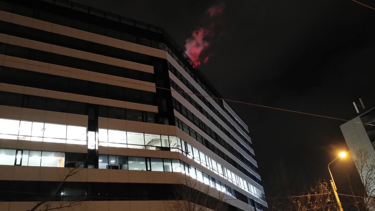 edificio alto y moderno de noche con luces rojas