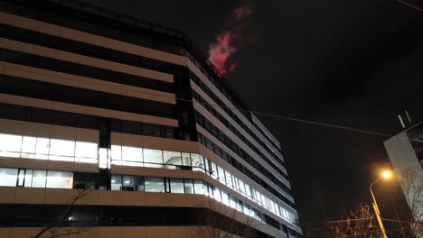 tall modern building at night with red lights