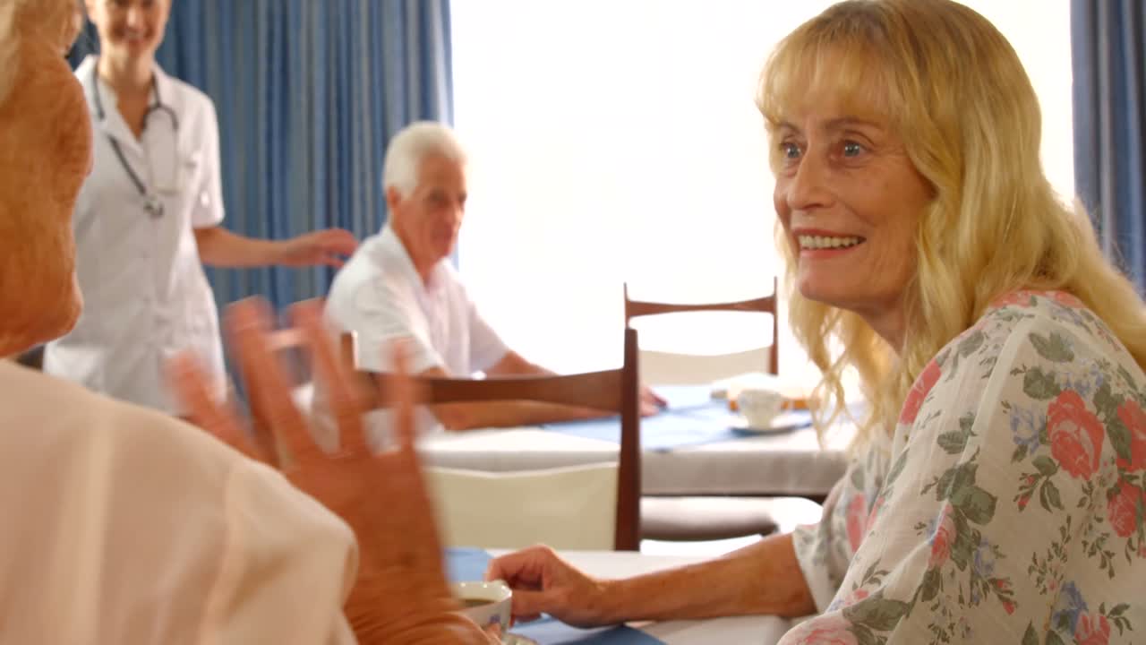 여성 의사 가 그 들 을 향해  ⁇ 고 있을 때 서로 대화 하는 고위 여성