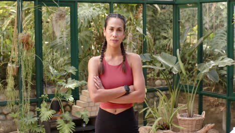 standing confidently, woman in sportswear with smartwatch in greenhouse garden