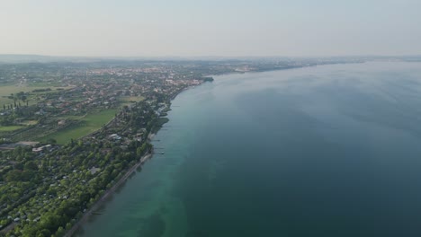 tranquility scene of lake garda and city by the bay at daytime in northern italy