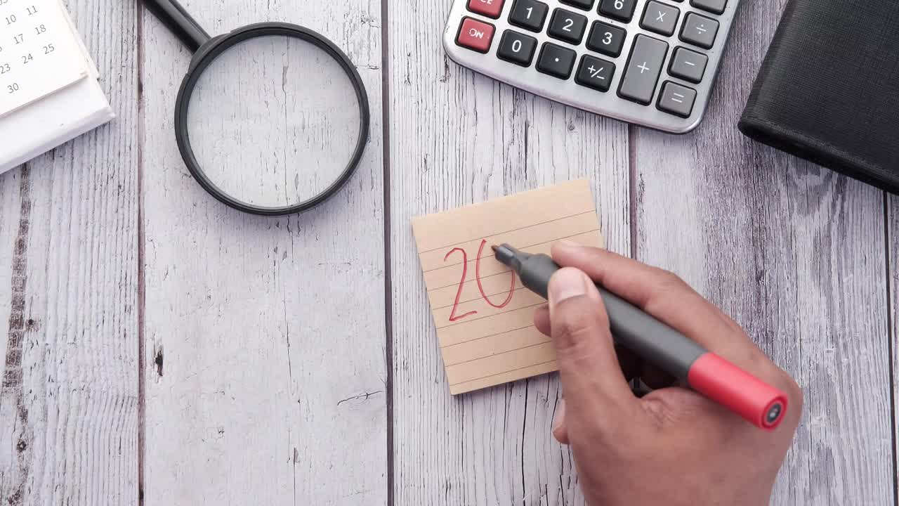 escritura a mano en el bloc de notas con suministros de oficina