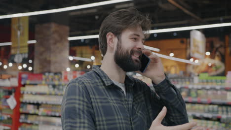 man shopping and talking on phone in grocery store