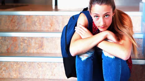 triste colegiala sentada sola en la escalera