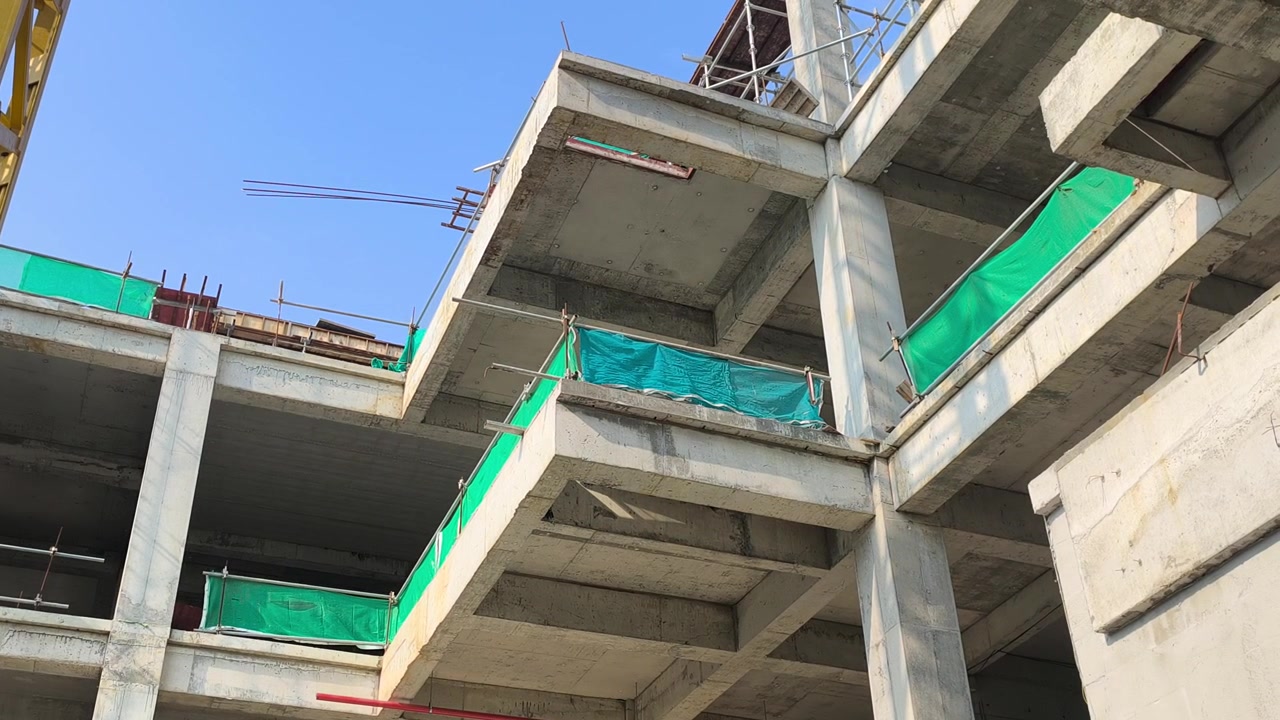 Toma en ángulo bajo de una viga en voladizo de hormigón armado que soporta una losa de piso. Vista estructural dentro de una obra de construcción moderna activa