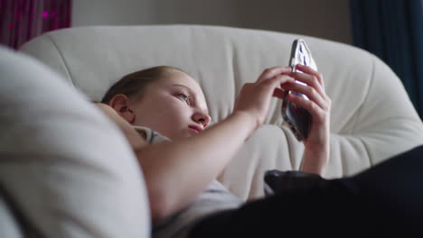 teenage girl using smartphone on a couch