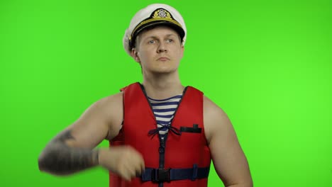 young muscular sailor man works as lifeguard at beach observe the territory