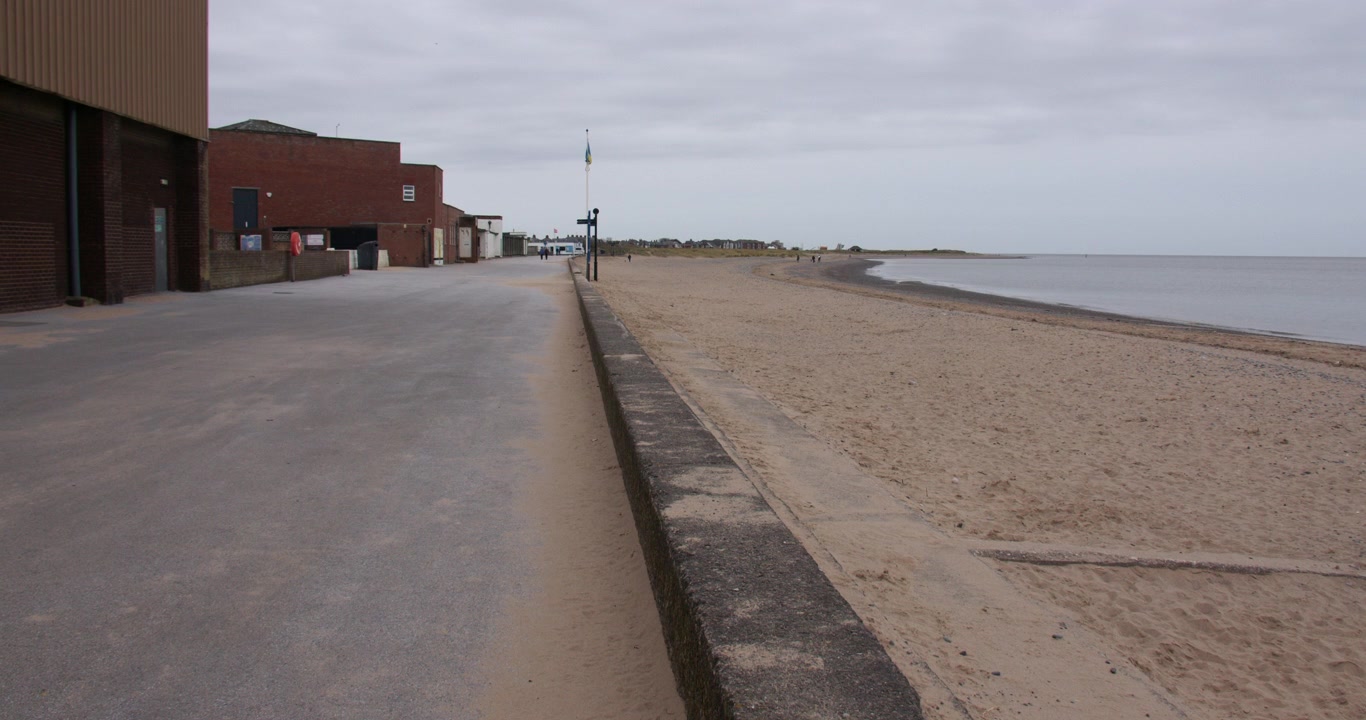Vidvinkelbilde som ser nedover den øde strandpromenaden i Fleetwood. På Marina beach