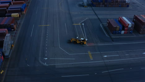 aerial view of a container terminal with a forklift at dusk or dawn