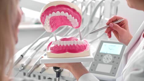 Dentist-showing-patient-the-artificial-dentures