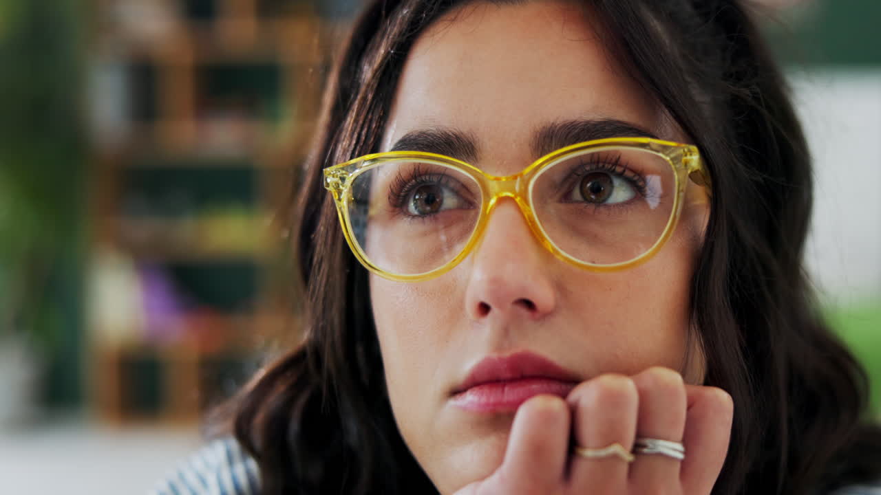 Woman with glasses looking thoughtful