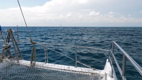 catamaran at sea with a small boat in the distance