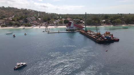 Aerial-circling-shot-of-platform-ferry-loading-cargo-freight-at-pier-of-GIli-Trawangan,Indonesia