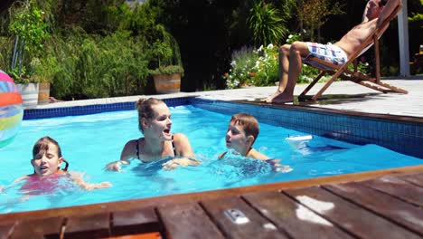 mother and kids swimming in pool