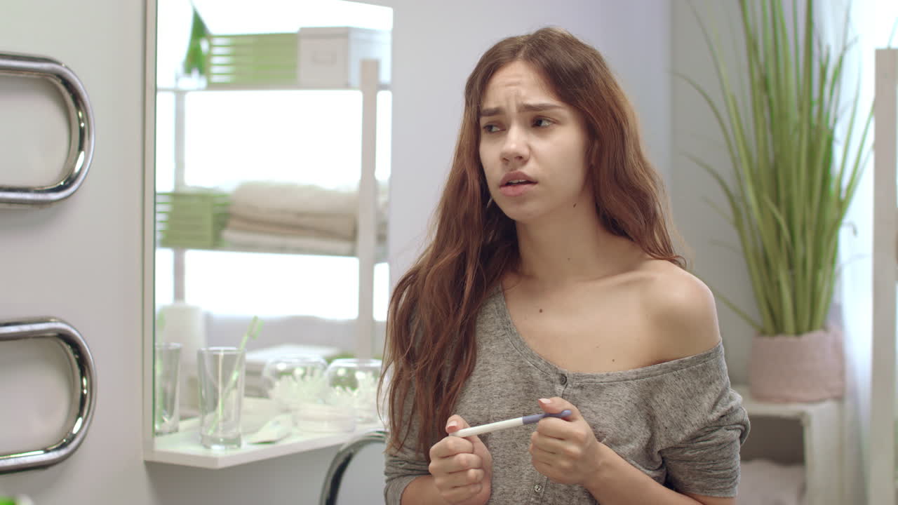 Woman waits pregnancy test results in bathroom. Girl does express ovulation test