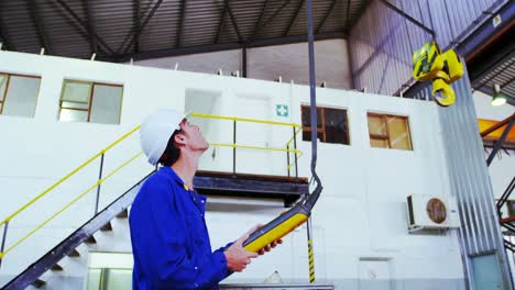 ingeniero masculino que opera una máquina de elevación en el taller 4k