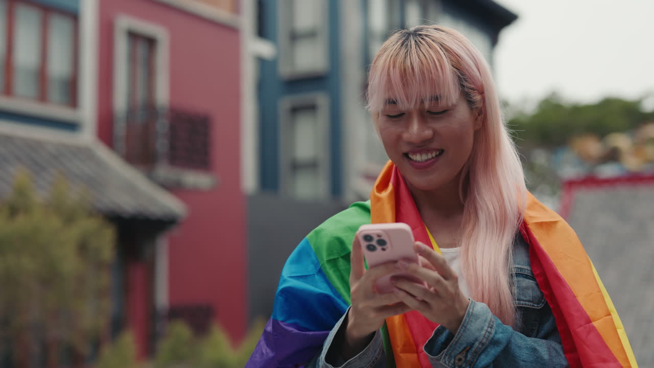 Person using a phone with Pride flag