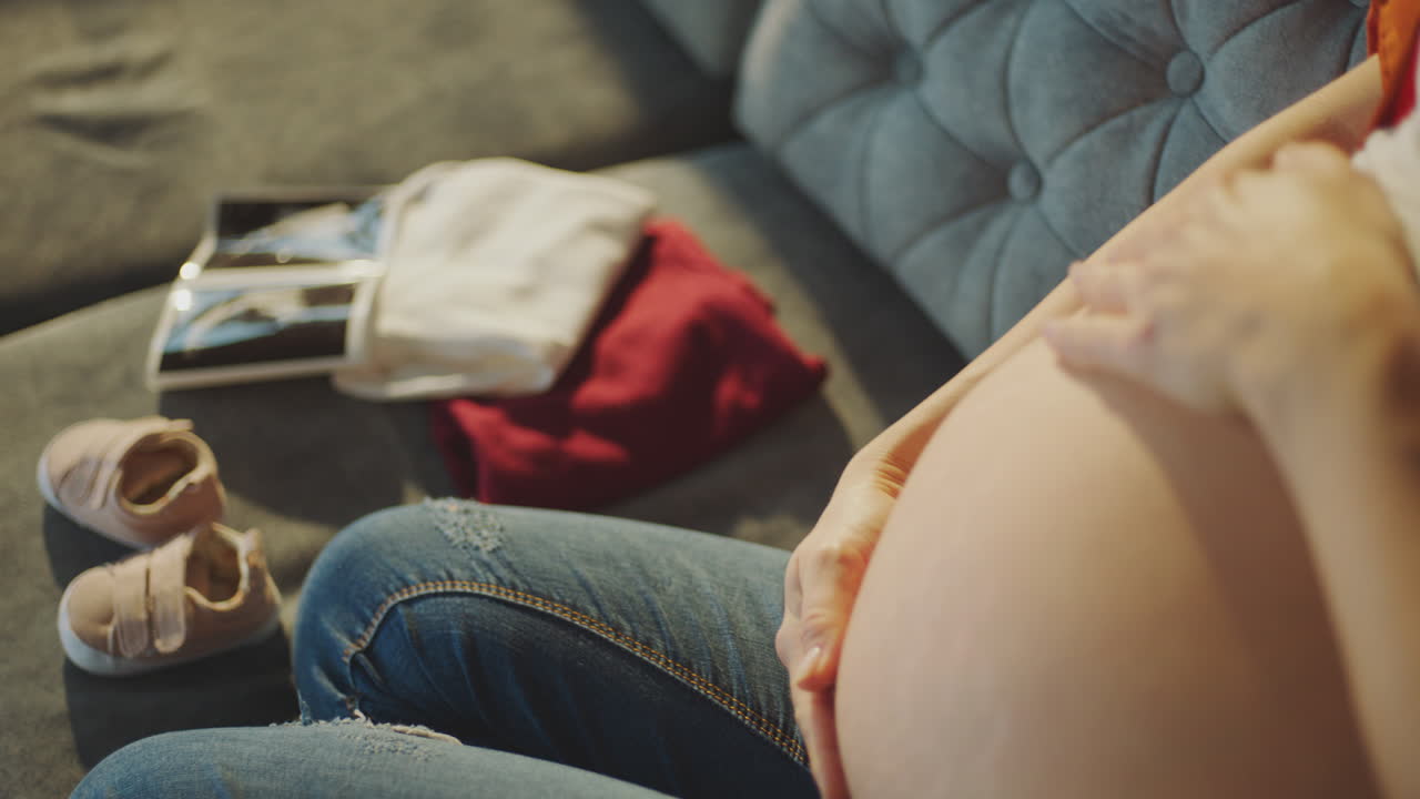 Pregnant Woman with Baby Items and Ultrasound Pictures