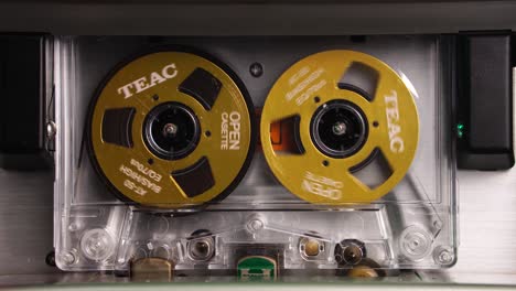 vintage teac audio cassette tape spinning reels during playback or recording, close up