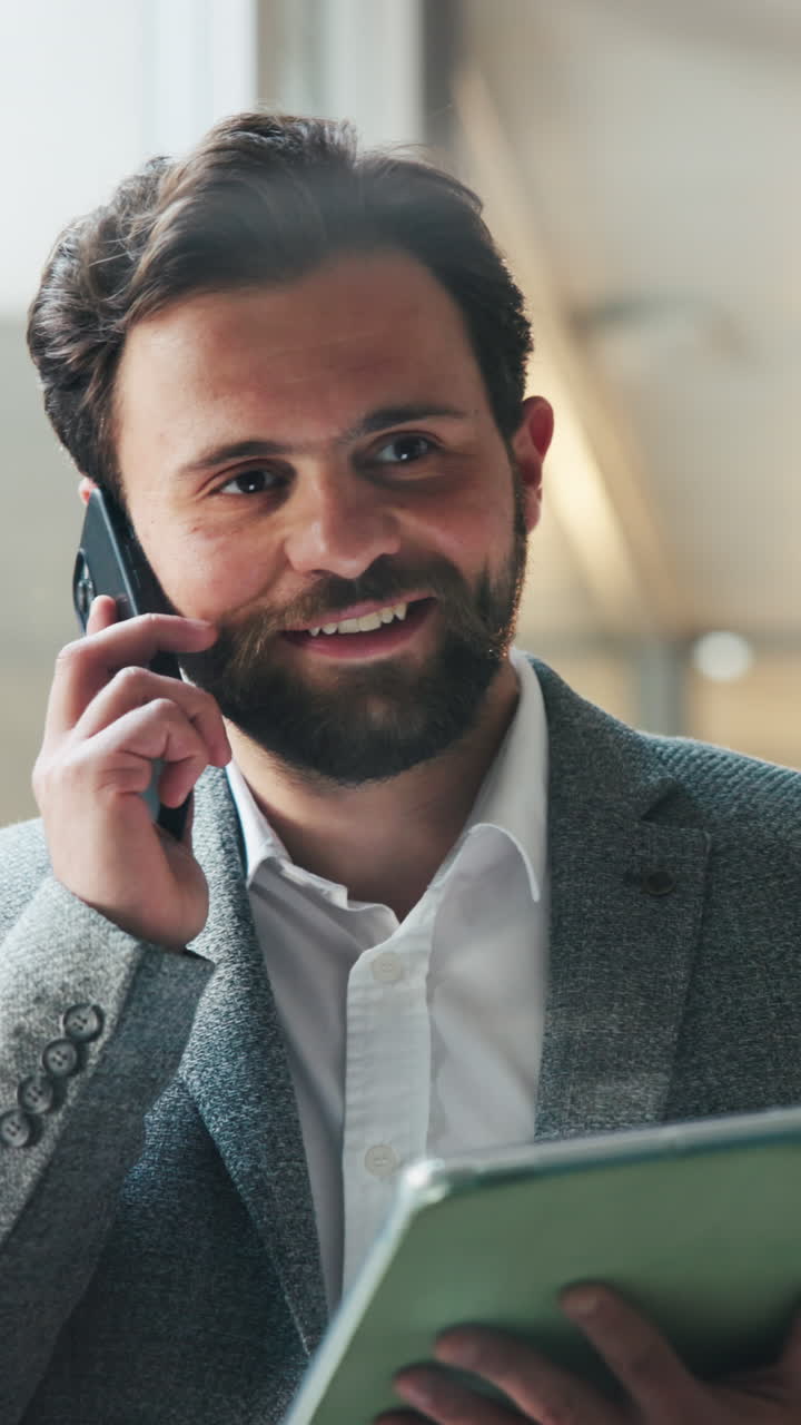 Bearded Businessman Talking on Phone and Using Tablet