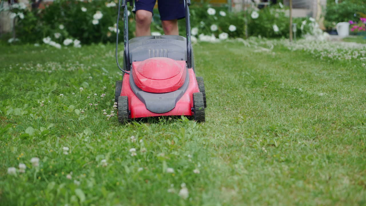 Boy mowing the lawn. Close-up