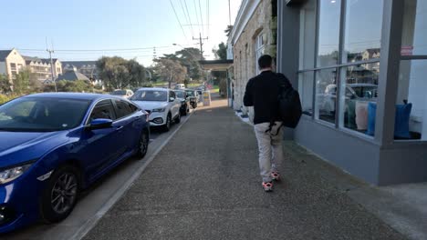 man walking along sidewalk in melbourne