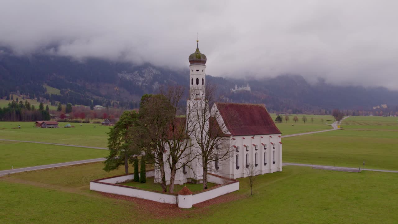 Igreja icônica de São Coloman em prado com o pano de fundo dos Alpes, Baviera, Alemanha