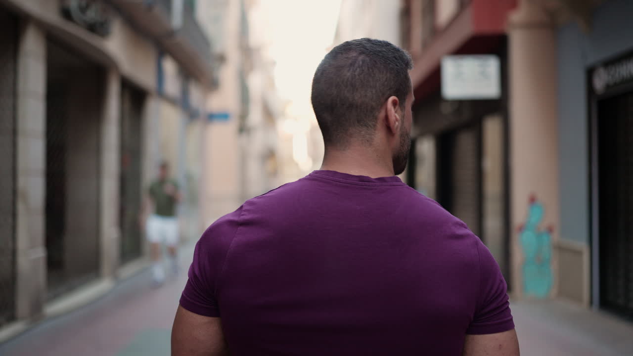 Young man walking through commercial street outdoors.