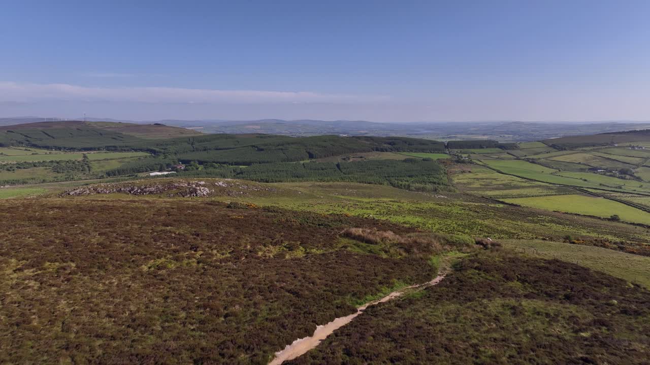 Grianan of Aileach, County Donegal, Ireland, June 2023. Drone pushes over the stone hillfort at Inishowen revealing the view south towards planted forests at Carrowreagh and Bohullion on a sunny day.