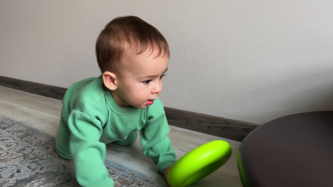 Baby Crawling and Playing with a Green Ring Toy