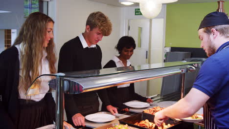 teenage students being served meal in school canteen