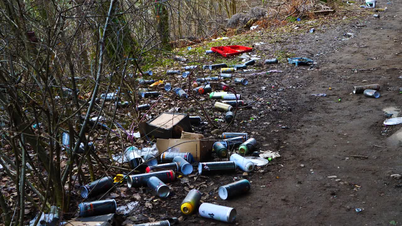 Empty Cans Of Spray Paint Littered On Forest Ground In Sweden