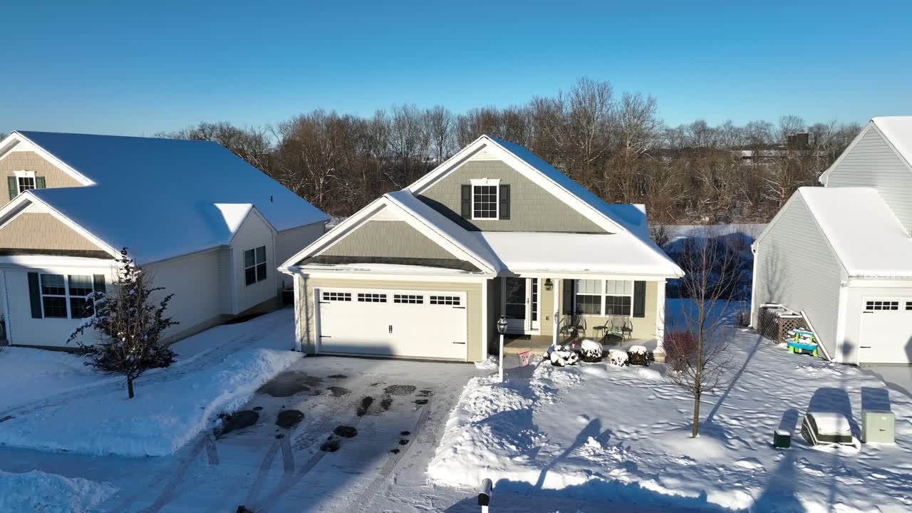 toma aérea de aproximación de una casa estadounidense con iluminación de garaje por el sol