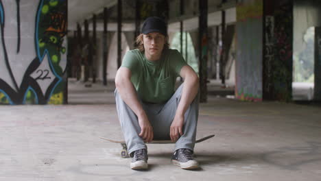 skateboarder caucásico en un edificio en ruinas.