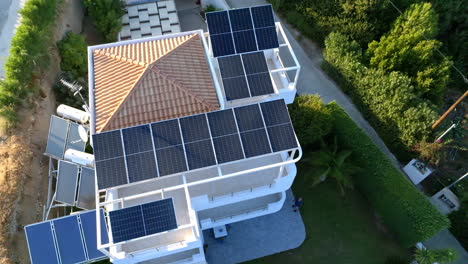 aerial tilt shot backwards over a solar powered house, golden hour in greece