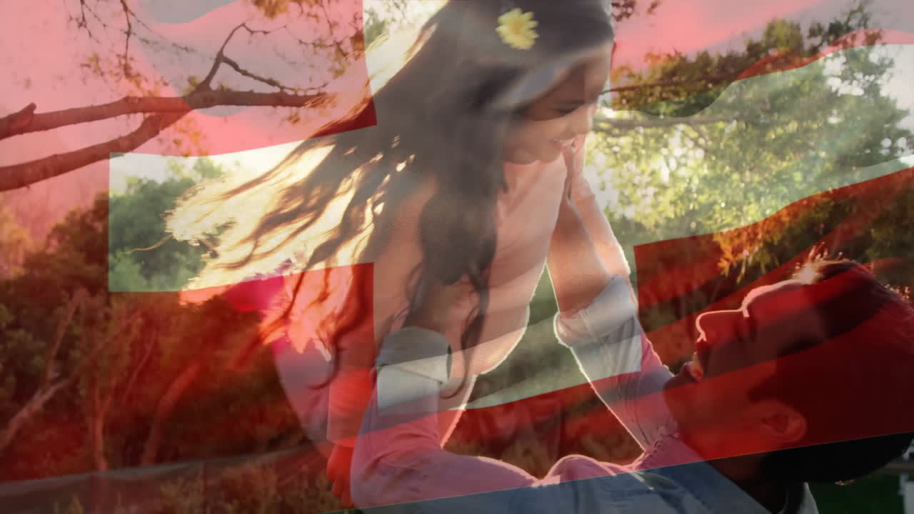 Father lifting child outdoors with Swiss flag overlay in playful moment