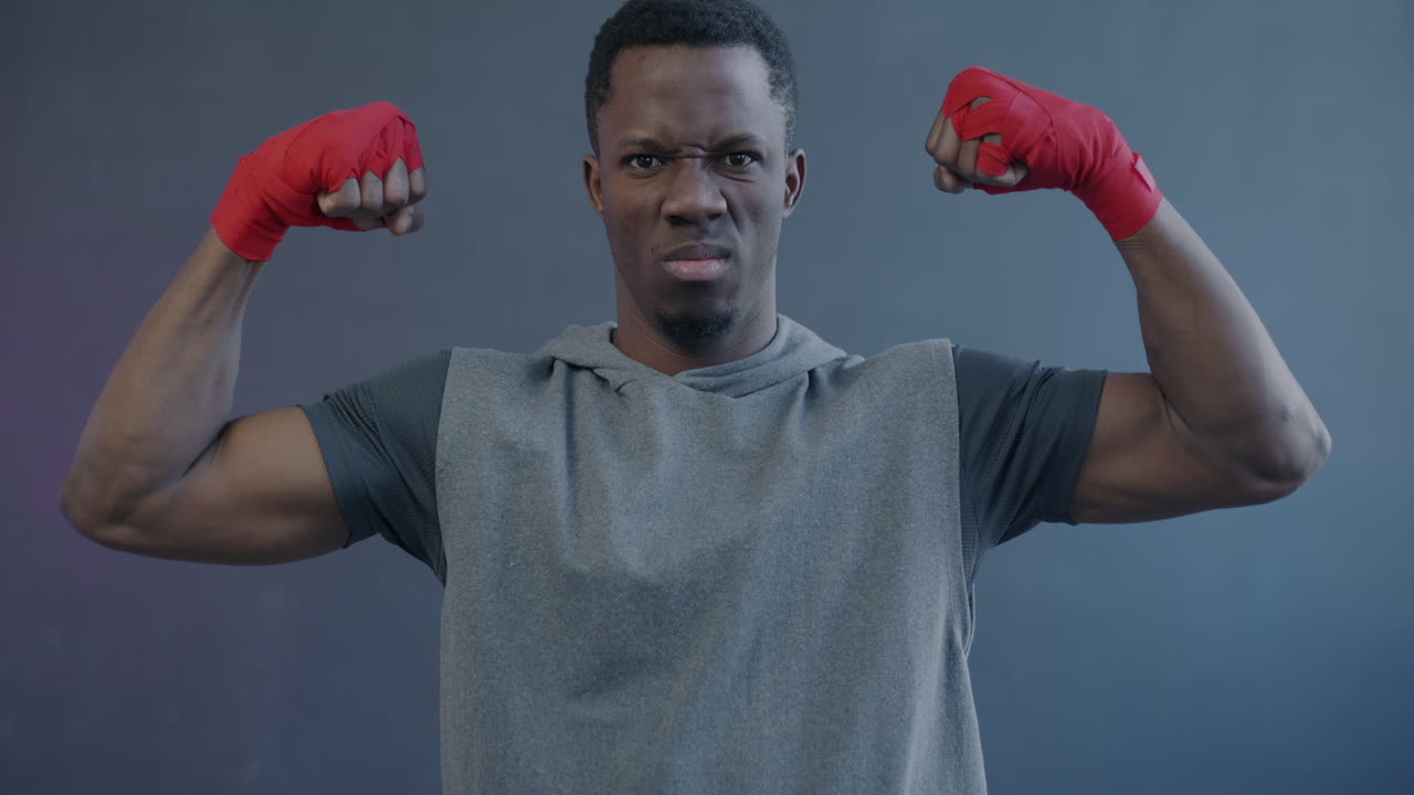 Man flexing muscles with boxing wraps