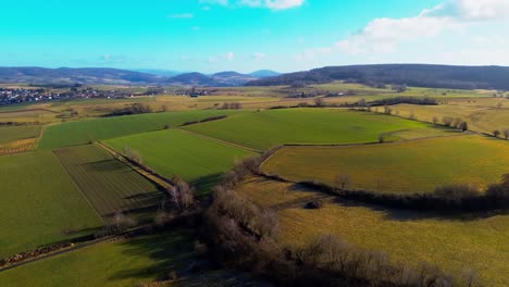 Panorama-Aéreo-De-Variadas-Tierras-De-Cultivo-Ubicadas-En-Un-Valle-Tranquilo