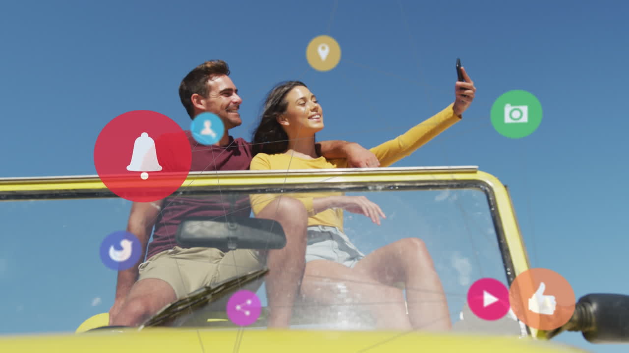 animación de iconos de los medios sobre una pareja caucásica que usa un teléfono inteligente
