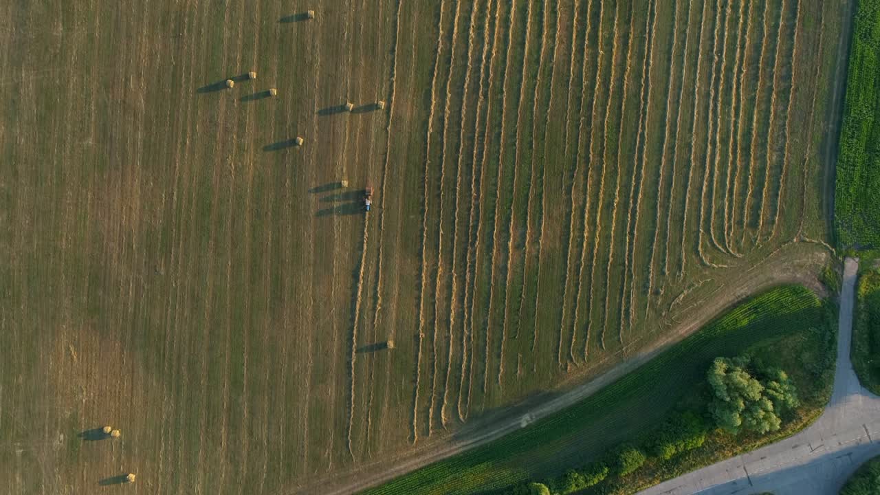 공중에서 위로 보는 트랙터 발링 기계는 농경지, 풀에서 실레이지 발링을 만니다.