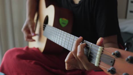mujer irreconocible aprendiendo a tocar un instrumento de guitarra