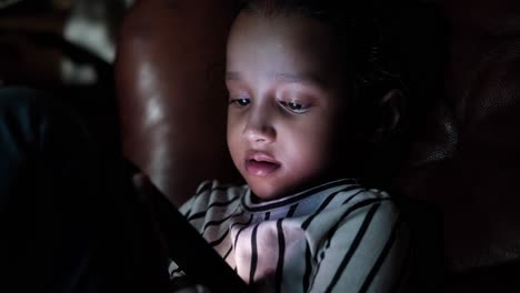 una chica joven usando un teléfono inteligente por la noche.