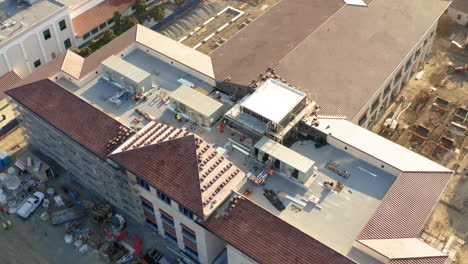 aerial view of a large building under construction with workers and hvac installation
