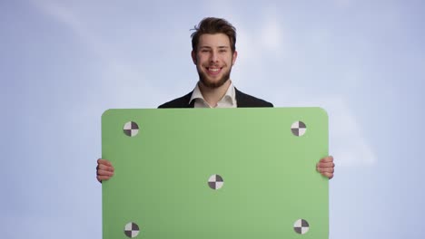 self confident man is presenting his green promotion card