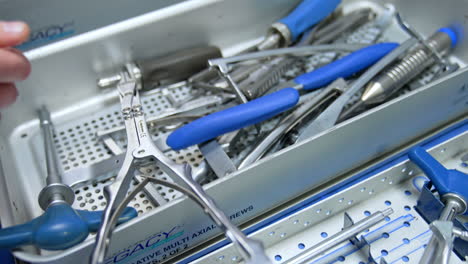 metal boxes with medical instruments. unrecognized students take and check the tools for neurosurgery. close up.