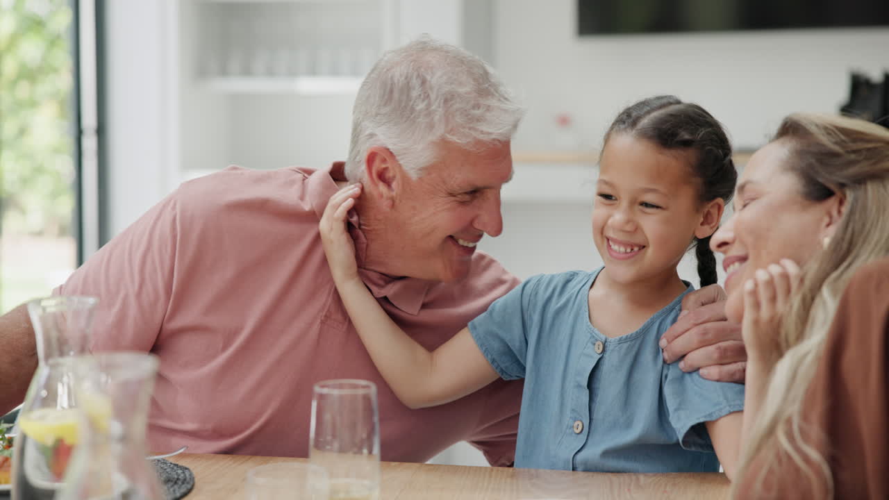 할아버지, 할머니와 손녀가 식사를 즐기고 있습니다.